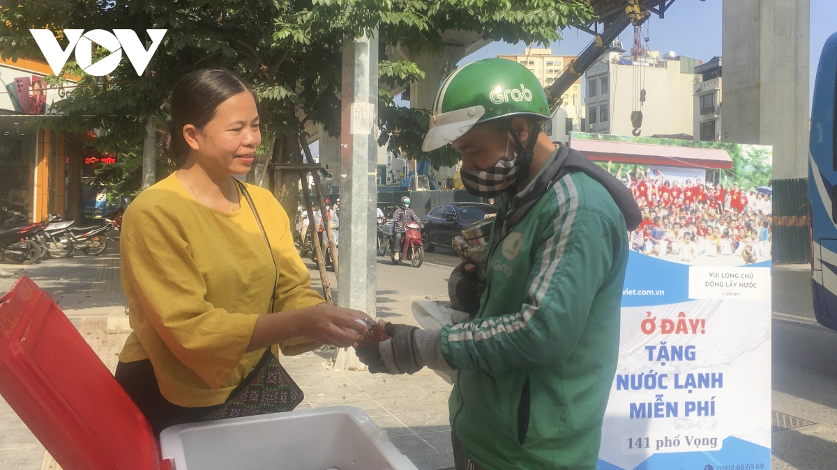 Người phụ nữ tặng nước cho lao động nghèo trên phố Hà Nội